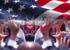 manos de ciudadanos alzadas bajo la imagen de una bandera norteamericana