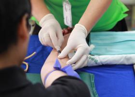 Personal médico toma una muestra de sangre de un hombre