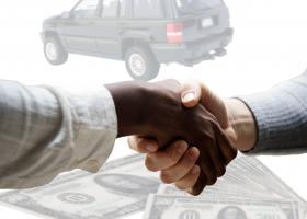 dos personas dándose la mano en señal de cerrar la compraventa de un coche