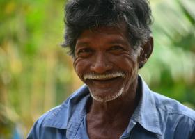 Hombre mayor de apariencia pobre sonriendo