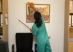 mujer realizando labores de limpieza en una oficina