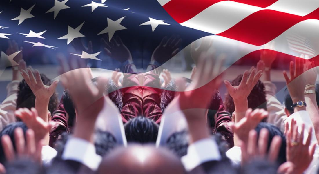manos de ciudadanos alzadas bajo la imagen de una bandera norteamericana