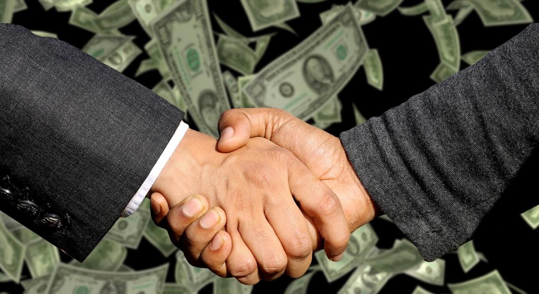 Un fondo de lluvia de billetes de dolar con unas manos estrechándose en señal de cerrar el trato. Imagen de Capri23auto en Pixabay.