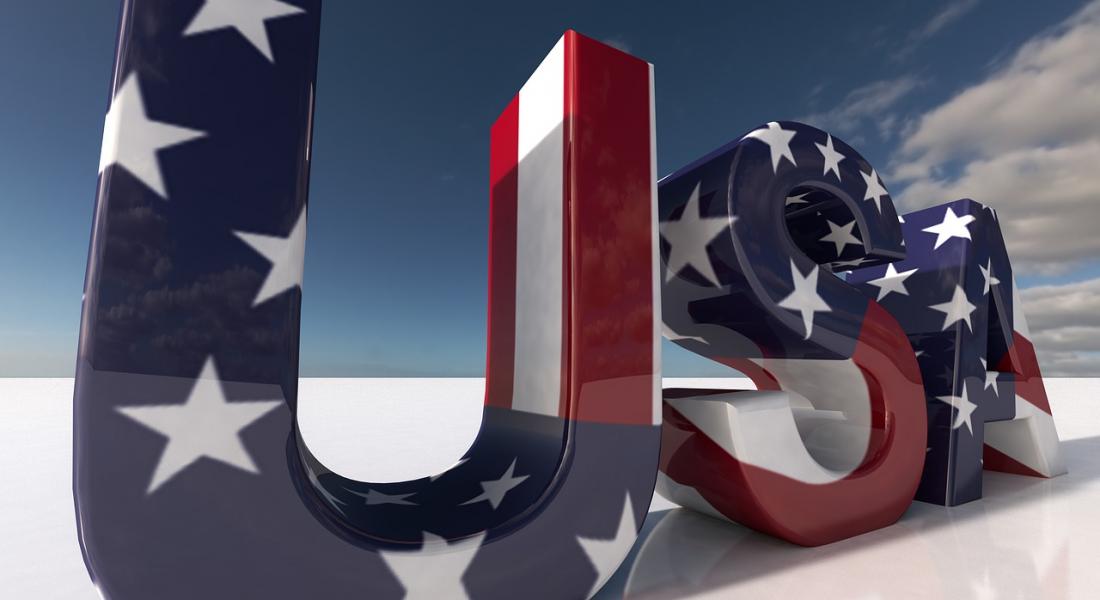 Enormes siglas USA con las barras y las estrellas de la bandera norteamericana colocadas en un terreno de arena